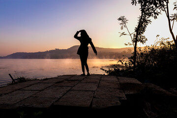 silhouette of a person on the lake at sunrise