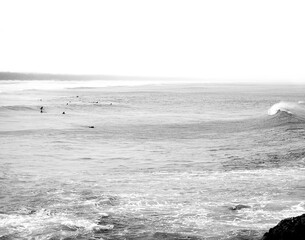 Minimalism - A group of surfers sit as a wave approaches them