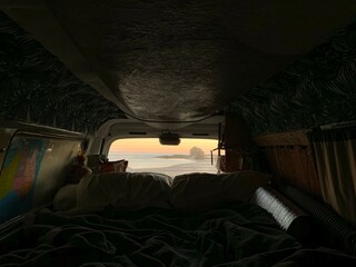 Australia's popular vanlife culture - The inside of a backpackers van overlooking sunrise at...