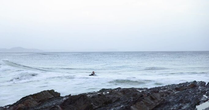 Waves Crashing at Snapper Rocks Gold Coast with Surfer Waiting in the Water