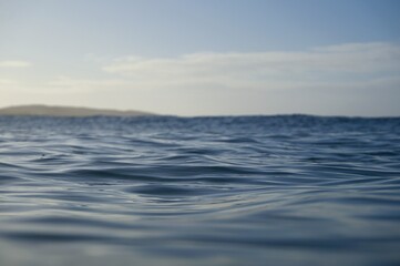 Fototapeta na wymiar Blue ocean water ripples in the fading evening light