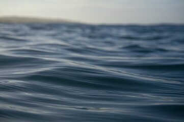 A close up shot of the blue waters of the Pacific ocean in the fading evening light