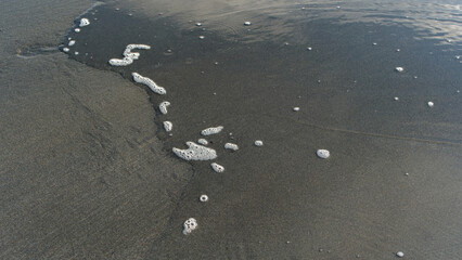 The waters edge on a sandy beach with no people about