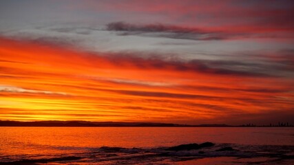 Fototapeta na wymiar A vibrant sunset over the Gold Coast bathes the sky in bright colours