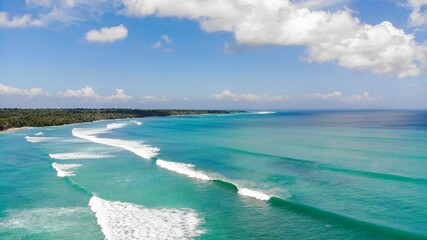 Looking across to the famous G-land wave in Java with multiple waves breaking in the tropical waters