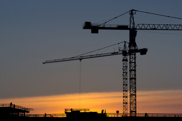 Construction site with a large construction crane on buildings. Modern building technologies. Construction crane against the background of the sky and unfinished buildings