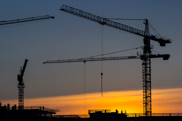 Construction site with a large construction crane on buildings. Modern building technologies. Construction crane against the background of the sky and unfinished buildings