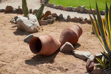 clay jugs on a flower bed