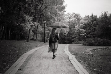 Young attractive smiling girl under umbrella in autumn forest