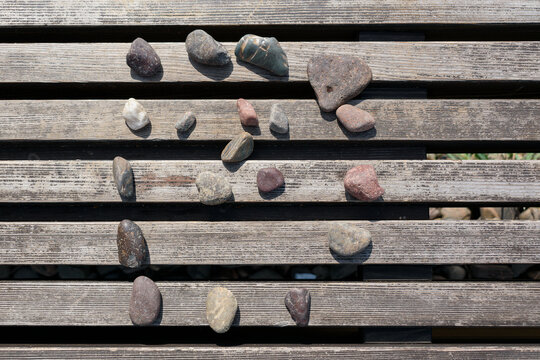 Stones laid out in a circle on a wooden lattice.