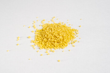Heap of raw organic couscous uncooked organic close up detail on neutral background 