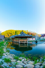 Fototapeta premium gazebo over the water in the mountains under the autumn sun