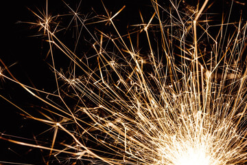New years eve sparkler isolated on black. Shiny blow of firework sparks. Empty copy space on black.