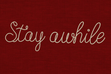 cursive font stay while text in rope effect on a textured red background