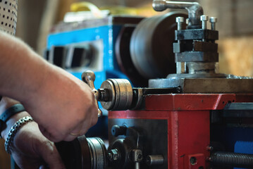 Naklejka premium Turner is working on the lathe machine close up.