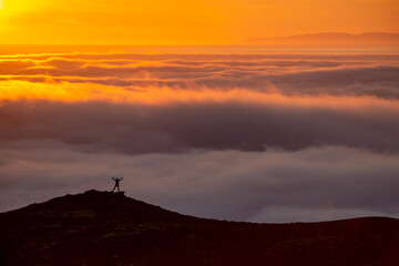 Dreamy misty landscape above the sea of clouds, mountains at sunset in Iceland