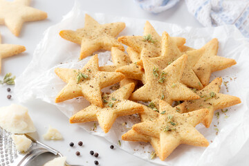 Star shaped savoury shortbread cookies with armesan cheese and black papper sprinkled with aromatic...