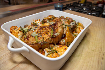 A delicious dish of Pork Pear sweet potato and stilton tray roast on a wooden kitchen work top