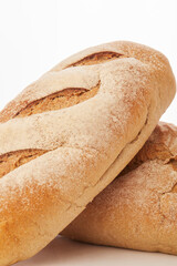 long loaf of whole wheat bread on white background.