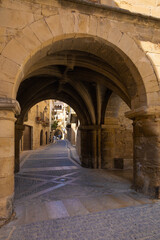 Fototapeta na wymiar View of one of the arcaded streets of the medieval historic center of Calaceite, Aragon, Spain
