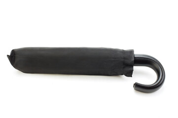 Black men's umbrella folded in a case and lying on a white background. Close-up. Full depth of field.