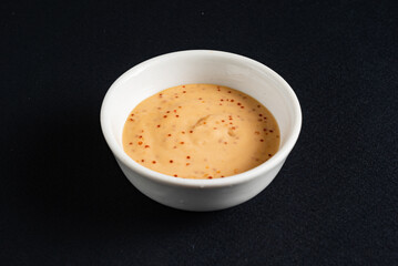 sauce in the bowl on the black background