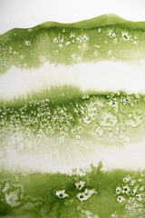 Hintergrund, grünes Aquarell mit Salztechnik wirkt wie eine Wiese oder Pflanze mit  weiße Blüten  oder Sternen