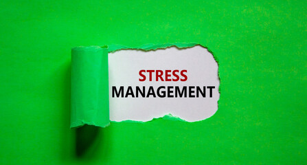 Stress management symbol. Words 'Stress management' appearing behind torn green paper. Business, psychological and stress management concept. Copy space.