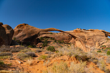 thin arch rock formation hiking trail in the desert