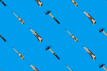 Tools seamless pattern. Tools: hammer, screwdriver and knife on a blue background.