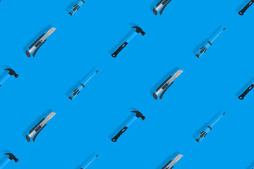 Tools seamless pattern. Tools: hammer, screwdriver and knife on a blue background.