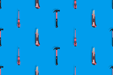 Tools seamless pattern. Tools: hammer, screwdriver and knife on a blue background.