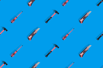 Tools seamless pattern. Tools: hammer, screwdriver and knife on a blue background.