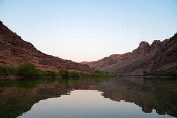 calm river surrounded by red mountain formations