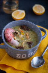 Sea food soup, Spicy Soup with Shrimps and mussels in a gray bowl on dark background, Thailand food.