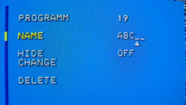 Settings menu on an old TV. Channel name setting. Blue pixel background. Retro tv. Macro close up.