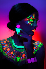Close up UV front portrait of a young woman with artistic colorful makeup, isolated violet orange background.