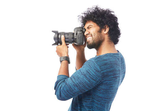 Cheerful smart young man posing with Dslr camera isolated on white.