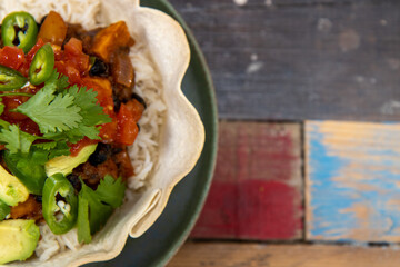 A delicious black bean burrito bowl on a pink wooden kitchen work top