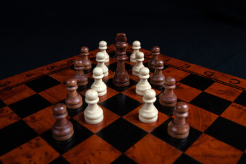 chess pawns and king on a board on a black background