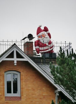 Weihnachtsmann wikt vom Dach herunter