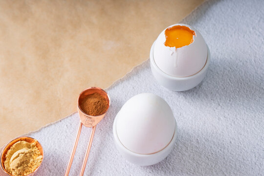 selective focus. fresh chicken egg in a white ceramic egg stand on a light background