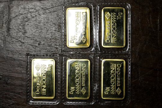 sealed 10 grams Degussa gold ingots on wooden background