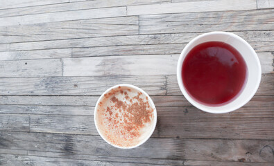 take away red tea and cappuchino on the wooden table