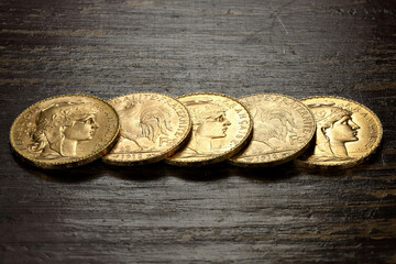 French 20 Francs gold coins on rustic wooden background