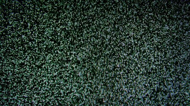 Real analog television noise. TV no signal. White noise. The TV reception is poor. Waves of static grainy noise from an old analog tv screen. Macro close up.