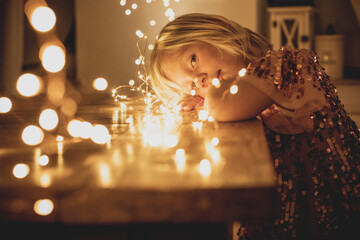 pretty,blonde child,girl in romantic christmas mood with lights and christmas balls 