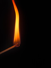 burning match stick on black background