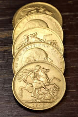British full Sovereign gold coins (Edward VII) on rustic wooden background