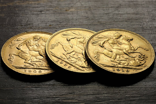 British full Sovereign gold coins (Edward VII) on rustic wooden background